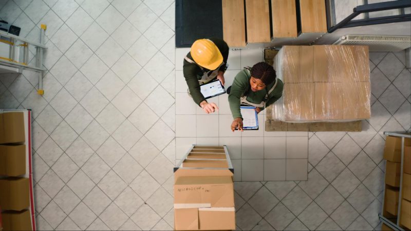 warehouse workers inspecting boxes and checking inventory